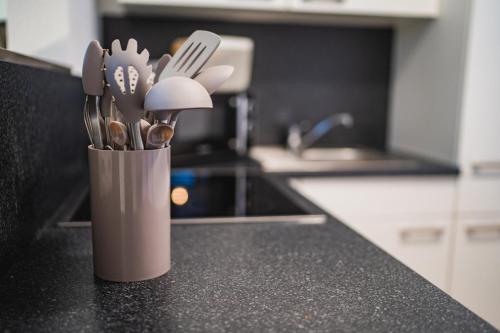 a container of utensils sitting on a kitchen counter at Weberhof Ferienapartments in Rostrup am Westufer des Zwischenahner Meers in Bad Zwischenahn
