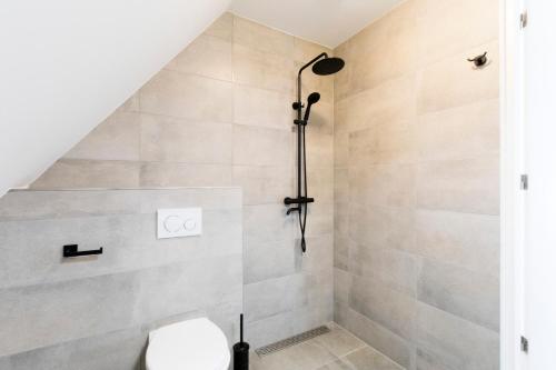 a bathroom with a shower with a toilet at The island life Texel - Wellness in De Koog