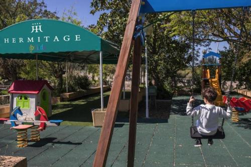 a young child on a swing at a playground at Hotel Hermitage in Galatina