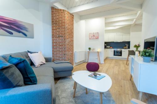a living room with a couch and a table at Weberhof Ferienapartments in Rostrup am Westufer des Zwischenahner Meers in Bad Zwischenahn