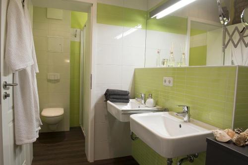 Stolpe auf Usedom的住宿－Der Westflügel Landrat Erdmann，绿色浴室设有两个盥洗盆和卫生间