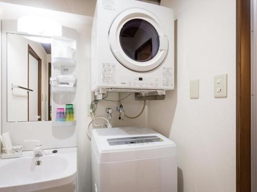 y baño con lavadora y lavamanos. en Ryujin Hotel Ukishima, en Naha