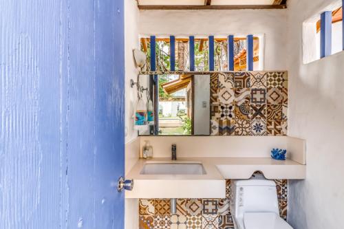 a bathroom with a sink and a mirror at Casa La Palapa Main House in Tivives