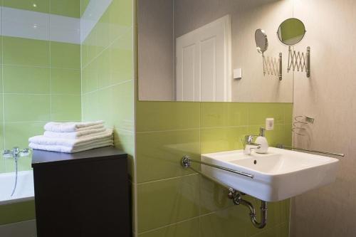 Baño verde con lavabo y espejo en Der Westflügel Ritter Florin, en Stolpe auf Usedom