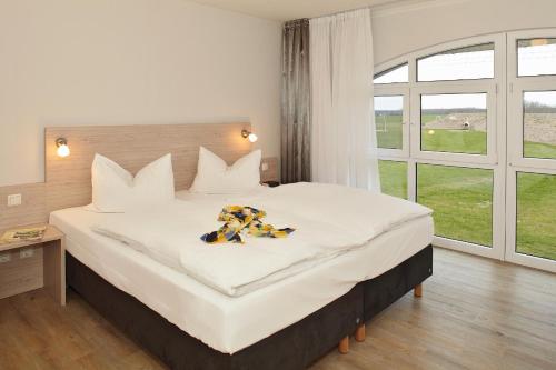 a bedroom with a large bed with a large window at Der Landhof Strandhafer in Stolpe auf Usedom