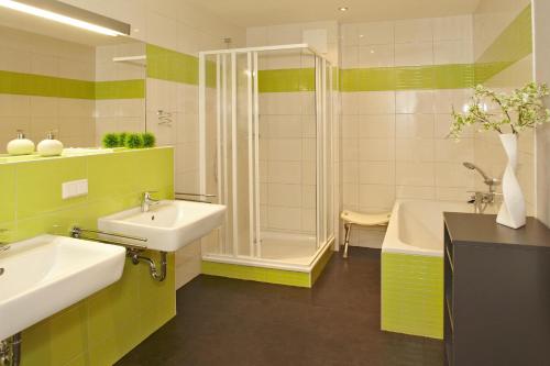 a bathroom with two sinks and a shower and a tub at Der Landhof Strandhafer in Stolpe auf Usedom