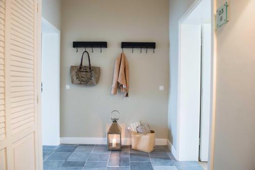 a hallway with a lantern on the wall and a coat rack at Die Remise Halla in Stolpe