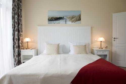 - une chambre avec un grand lit blanc et deux lampes dans l'établissement Die Remise Halla, à Stolpe