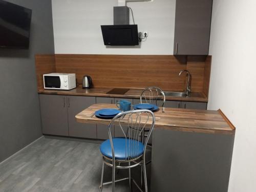 - une cuisine avec un comptoir, 2 chaises et un évier dans l'établissement Нова квартира в центрі міста, à Oujhorod