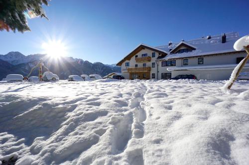 a snow covered yard with the sun in the background at Apart-Hotel Dreisonnenhof in Fiss