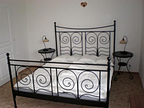 ein schwarzes Bett mit zwei Tischen und zwei Lampen in der Unterkunft Penzion "Apartmány U Semušky" in Pernink