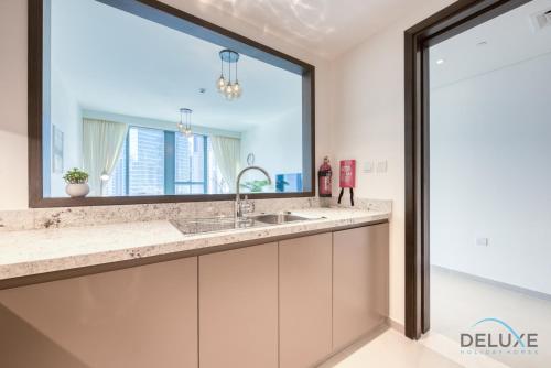 a bathroom with a sink and a large mirror at Stylish 1BR Apartment at Blvd Heights Downtown Dubai by Deluxe Holiday Homes in Dubai