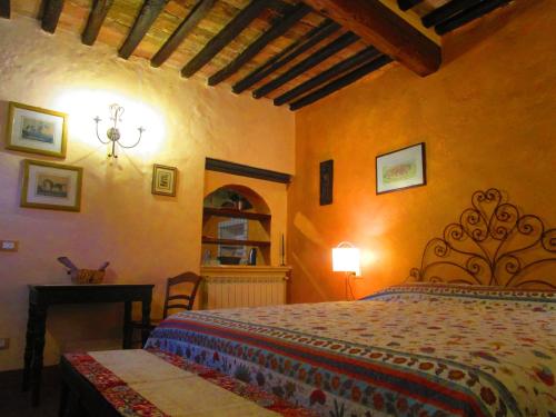 1 dormitorio con 1 cama y 1 mesa en una habitación en Il Mandorlo di Monteriggioni en Monteriggioni