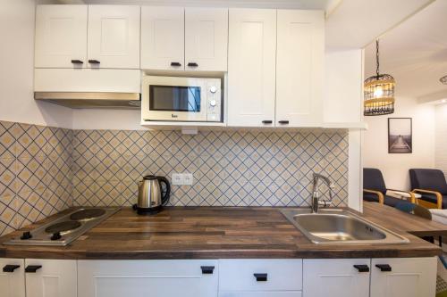 a kitchen with a sink and a microwave at DayFlat Apartments Golden Gate Area in Kyiv