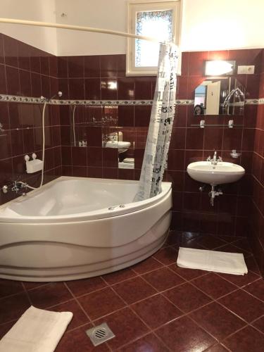 een grote badkamer met een bad en een wastafel bij A-BB-LAK in Hajdúszoboszló