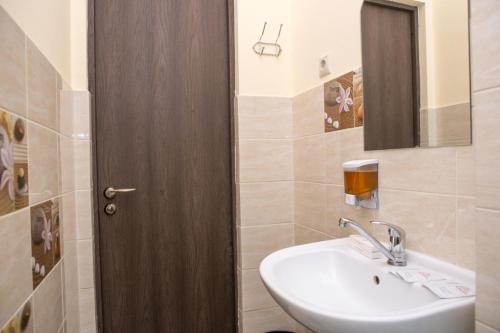 a bathroom with a sink and a wooden door at Roof in Sochi