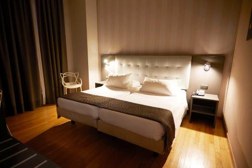 a bedroom with a large bed with white sheets and pillows at Hotel Concord in Turin