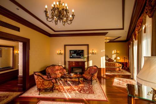a living room with a chandelier and a table and chairs at Nobilis Hotel in Lviv