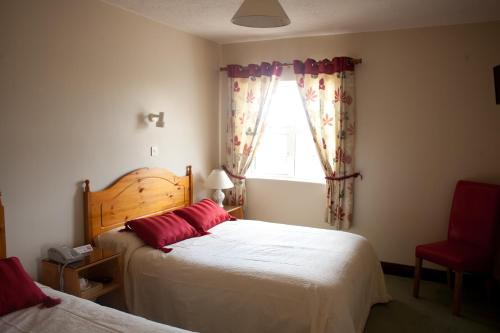 1 dormitorio con 2 camas y ventana en Grovemount House, en Ennistymon