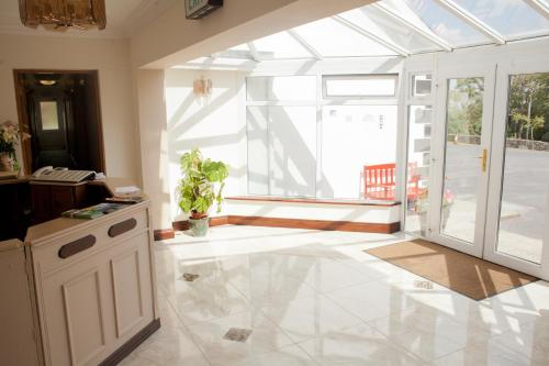 a living room with a large window and a white tile floor at Grovemount House in Ennistymon