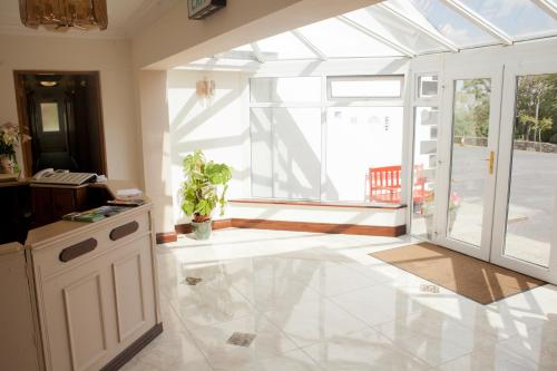 ein Wohnzimmer mit einem großen Fenster und einem weißen Fliesenboden in der Unterkunft Grovemount House in Ennistymon