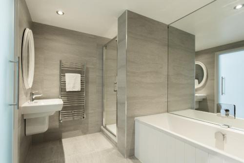a bathroom with a tub and a sink and a shower at The Idle Rocks in Saint Mawes