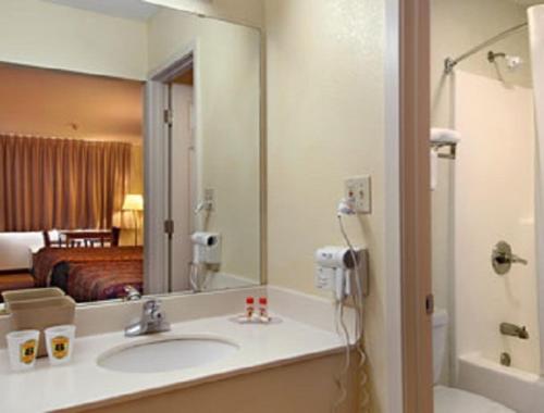 a bathroom with a sink and a large mirror at Super 8 by Wyndham Breaux Bridge in Breaux Bridge