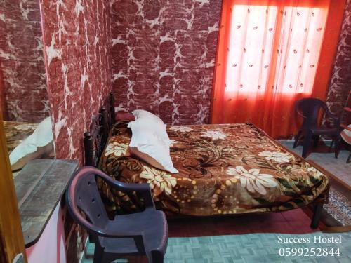 a small bed in a room with a table and chairs at Success Hostel in Nablus