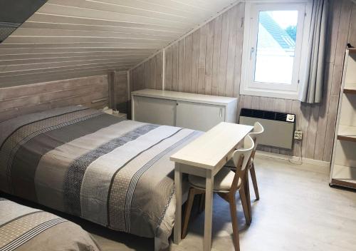 a bedroom with a bed and a table and a window at Westhinder in Wenduine