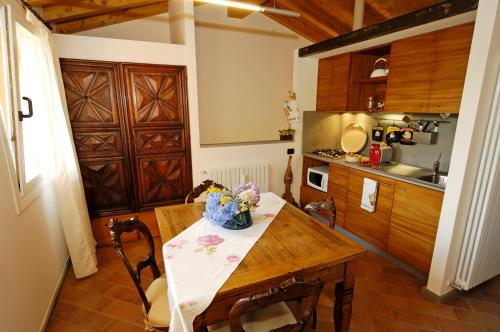 a kitchen with a wooden table with flowers on it at Agriturismo Terre Bianche in Teolo