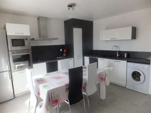 une cuisine avec une table et des chaises dans l'établissement Location saisonniere UZES 30700 6personnes, à Uzès