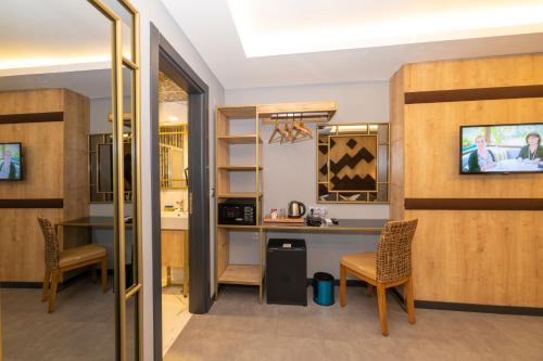 a room with a desk and two chairs and a table at Fly And Stay Airport Hotel in Istanbul