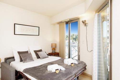 カンヌにあるColline Azur YourHostHelperの白いベッドルーム(ベッド1台、バルコニー付)