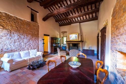a living room with a table and a stone wall at La Maestà antica dimora di campagna in Foligno