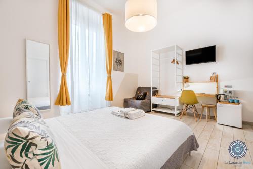 - une chambre avec un lit blanc et un bureau dans l'établissement La Casa dei Treni Affittacamere city rooms for travel lovers, à La Spezia