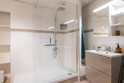 a white bathroom with a shower and a sink at Romantic Flat in the heart of the city in Avignon