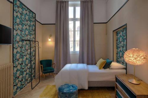 um quarto de hotel com uma cama e uma janela em Romantic Flat in the heart of the city em Avignon