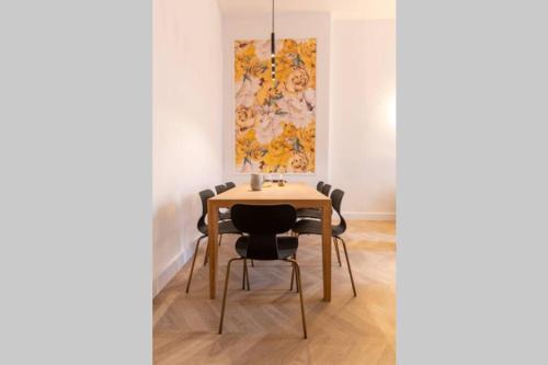 une table de salle à manger avec des chaises et un tableau au mur dans l'établissement Romantic Flat in the heart of the city, à Avignon