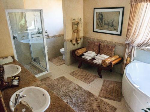 Tuscan Rose في Rooidam: حمام مع حوض ومغسلة ودش