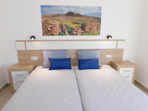 a bedroom with a bed with blue pillows at Casa Cho Silvestre in Tiscamanita