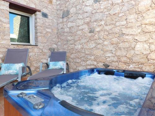 a jacuzzi tub in a room with two chairs at Casa Cho Silvestre in Tiscamanita