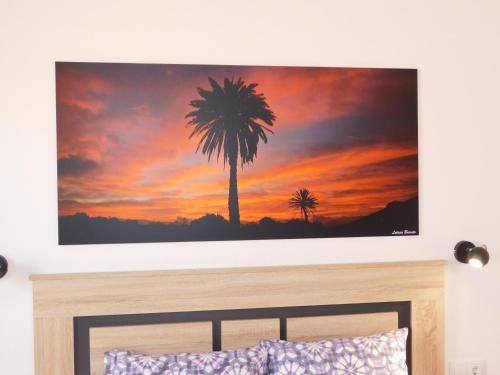 a painting of a palm tree on a wall above a bed at Casa Cho Silvestre in Tiscamanita