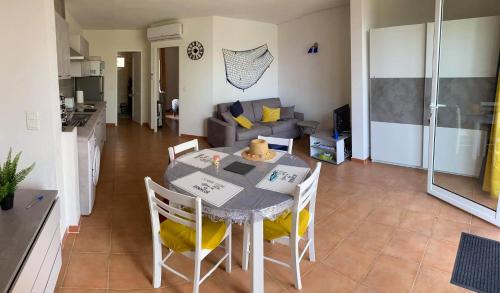 une cuisine et une salle à manger avec une table et des chaises dans l'établissement Appartement JOLY- Vue mer- Favone, à Conca