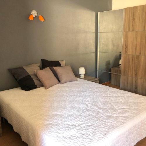 une chambre avec un grand lit avec des draps blancs dans l'établissement Appartement JOLY- Vue mer- Favone, à Conca