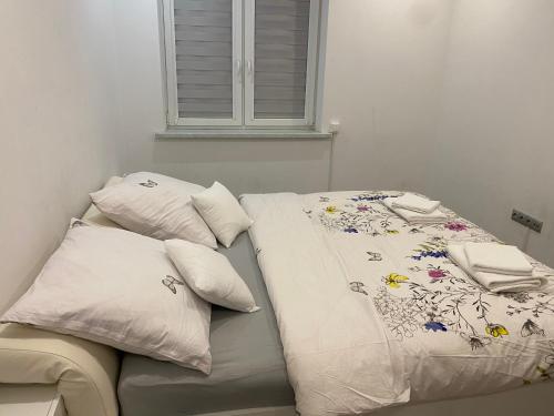 een bed met witte lakens en kussens erop bij VIP Apartments in Krosno Odrzańskie