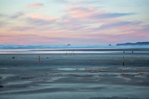 a beach with a cloudy sky and the ocean at Heron Condo in Moclips