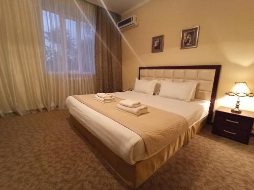 a bedroom with a large bed with towels on it at Silk Way Boutique Hotel in Osh