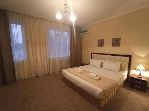 a bedroom with a bed with two towels on it at Silk Way Boutique Hotel in Osh