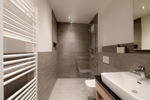 łazienka z prysznicem, toaletą i umywalką w obiekcie Simple Life Apartments w mieście Rauris