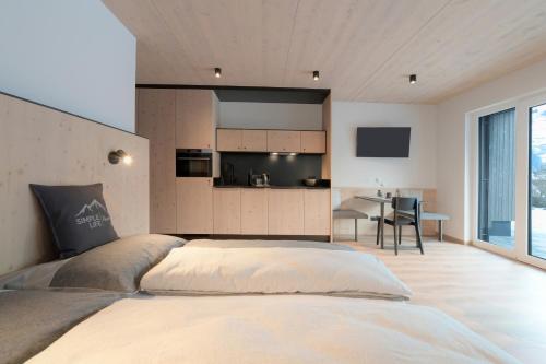 sypialnia z dużym łóżkiem i kuchnią w obiekcie Simple Life Apartments w mieście Rauris